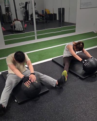 Two clients training together with medicine balls at Built by Faith Love Fitness